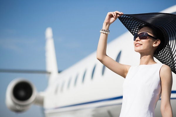 Woman with sun hat by Airplane